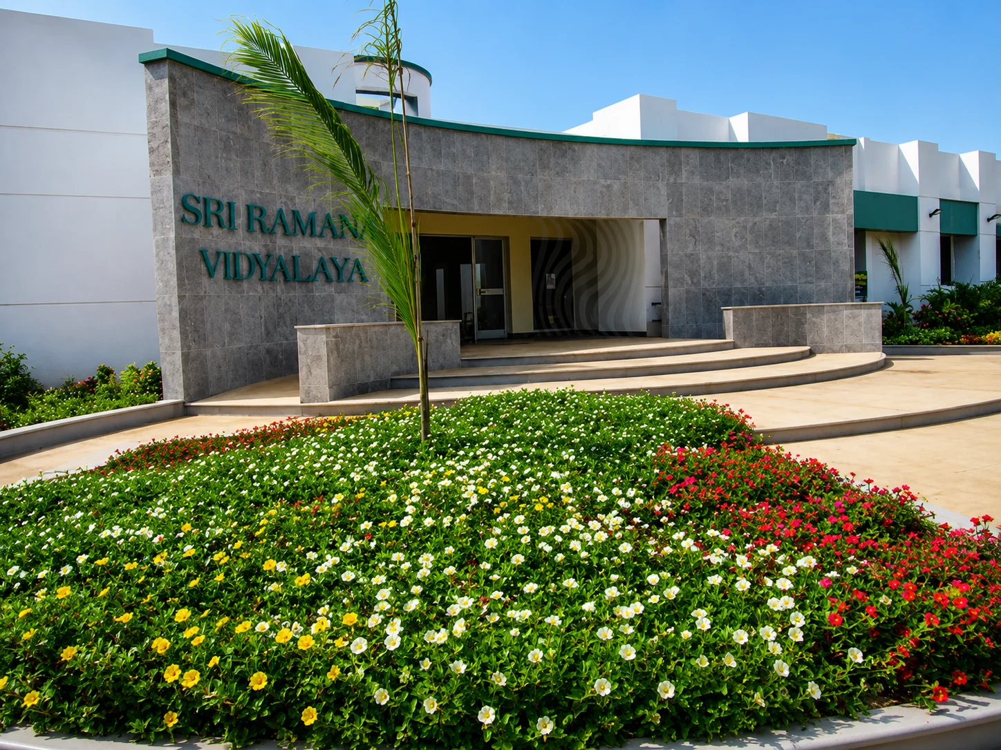 Institutional campus with landscaped gardens, flower beds, and walkways, showcasing functional and attractive landscape design.