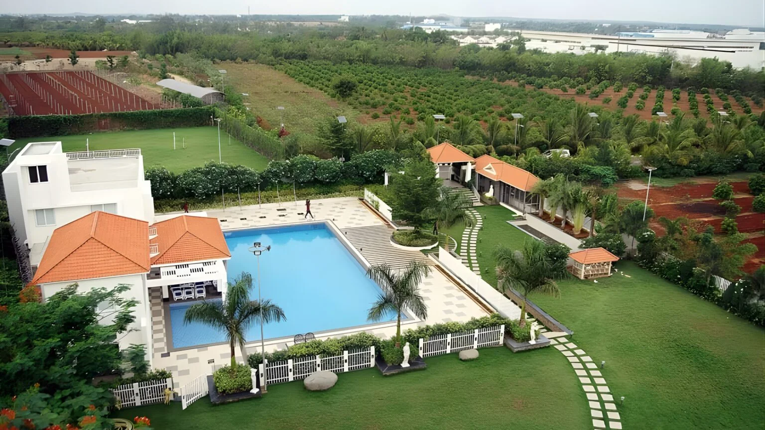 Aerial view of landscaped gardens, orchards, and a premium property showcasing sustainable green infrastructure.